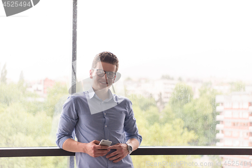 Image of Businessman Standing In A Modern Building Near The Window With P