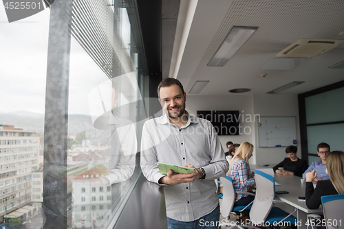 Image of Businessman Using Tablet In Office Building by window