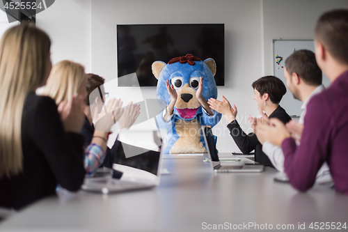 Image of boss dresed as bear having fun with business people in trendy of