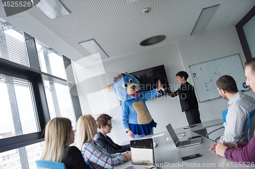 Image of boss dresed as bear having fun with business people in trendy of