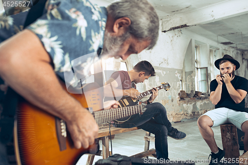 Image of Repetition of rock music band. Electric guitar player and drummer behind the drum set.