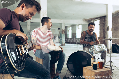 Image of Repetition of rock music band. Electric guitar player and drummer behind the drum set.