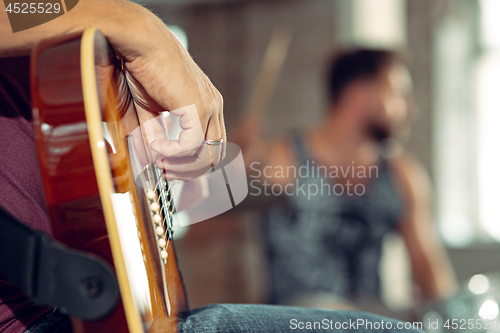 Image of Repetition of rock music band. Electric guitar player and drummer behind the drum set.