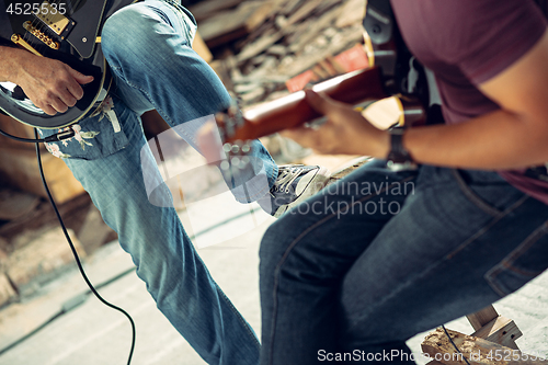 Image of Repetition of rock music band. Electric guitar player and drummer behind the drum set.