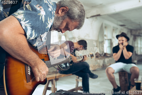 Image of Repetition of rock music band. Electric guitar player and drummer behind the drum set.