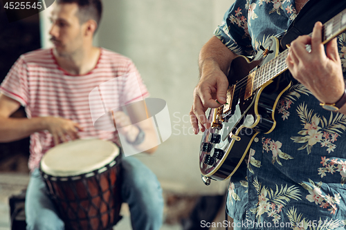 Image of Repetition of rock music band. Electric guitar player and drummer