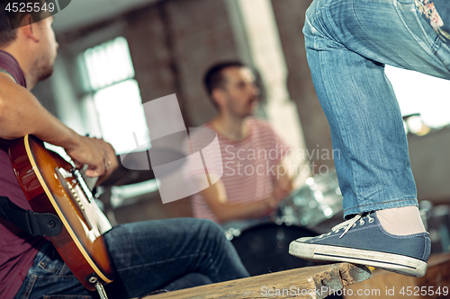 Image of Repetition of rock music band. Electric guitar player and drummer behind the drum set.