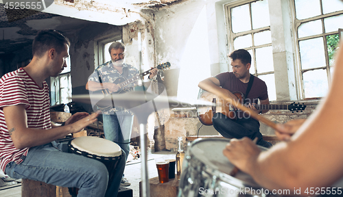 Image of Repetition of rock music band. Electric guitar player and drummer behind the drum set.