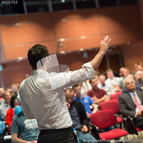 Image of Public speaker giving talk at Business Event.