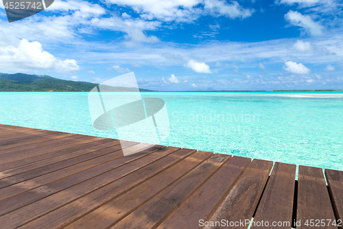 Image of wooden pier on tropical beach in french polynesia