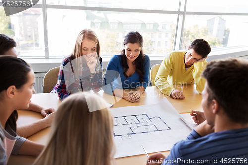 Image of group of smiling students with blueprint