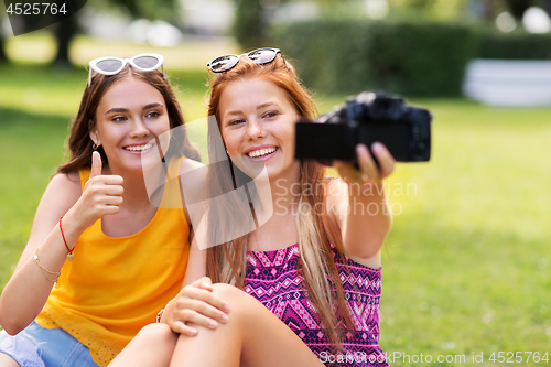 Image of teenage bloggers recording video by camera in park