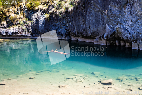 Image of Female floating in natural blue pools