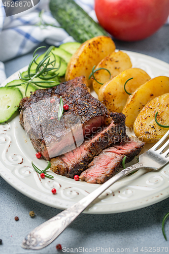 Image of Entrecote with fried potatoes and cucumber.