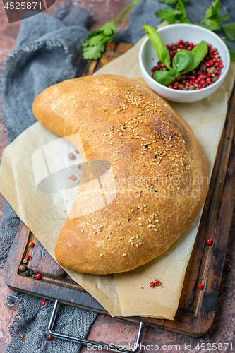 Image of Traditional pizza calzone on a wooden board.