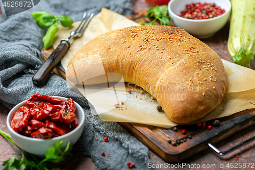 Image of Homemade pizza calzone on a wooden board.