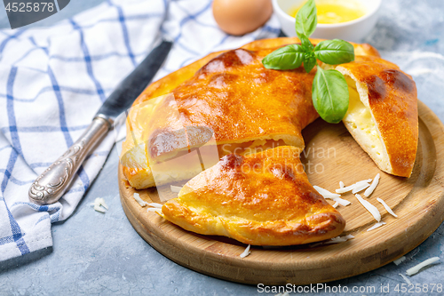 Image of Cut closed pie with cheese and egg (khachapuri).