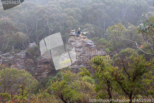 Image of Female hiker in Blue Mountains on top of pagoda in mist and fog