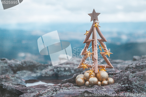 Image of Christmas tree with gold lights and mountain backdrop