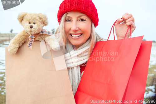 Image of Winter woman holding retail shopping or gift bags