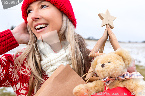 Image of Festive woman carring Christmas things... Christmas snowy backdrop