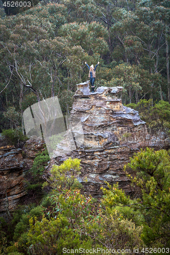 Image of Hiker exhilaration after climbing a pagoda in mountains