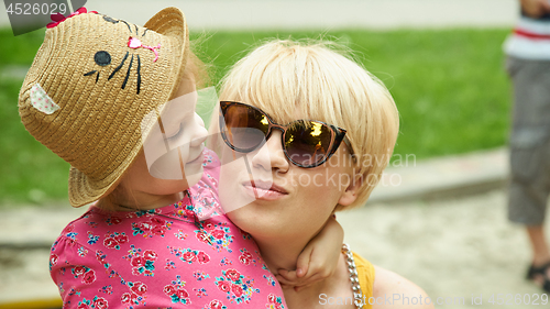 Image of mother and daughter hugging in love playing in the park
