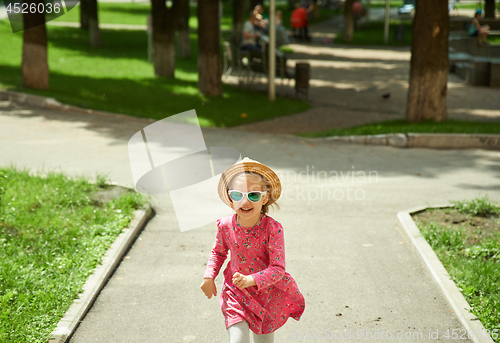 Image of Happy cute little girl running in the park. Happiness.