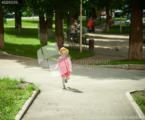 Image of Happy cute little girl running in the park. Happiness.