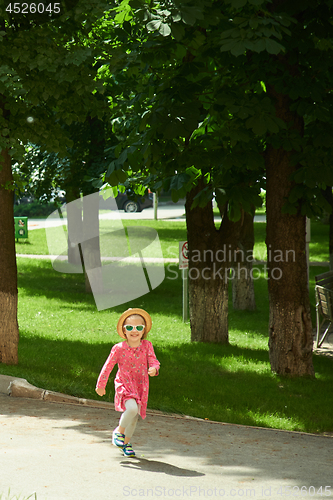 Image of Happy cute little girl running in the park. Happiness.