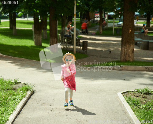 Image of Happy cute little girl running in the park. Happiness.