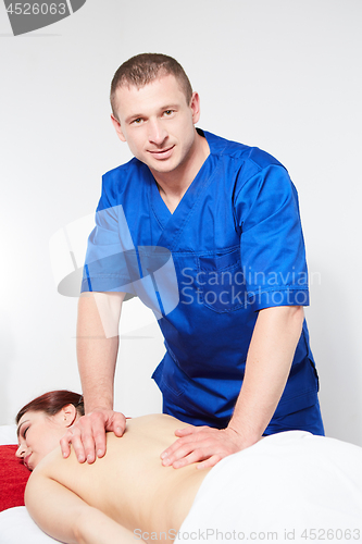 Image of Young woman having back massage.