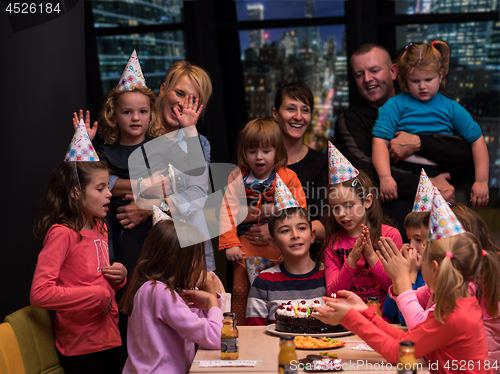 Image of happy young boy having birthday party