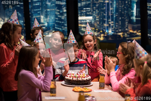 Image of happy young boy having birthday party