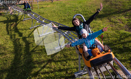 Image of young mother and son driving alpine coaster