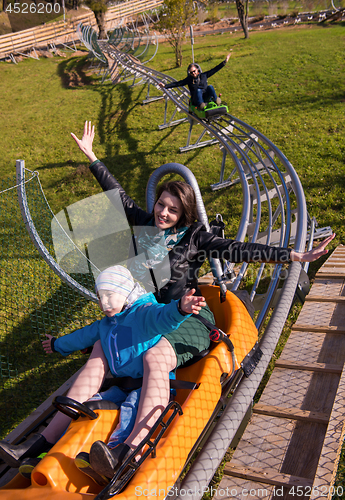 Image of young mother and son driving alpine coaster