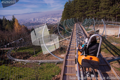 Image of young mother and son driving alpine coaster