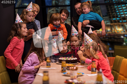 Image of happy young boy having birthday party