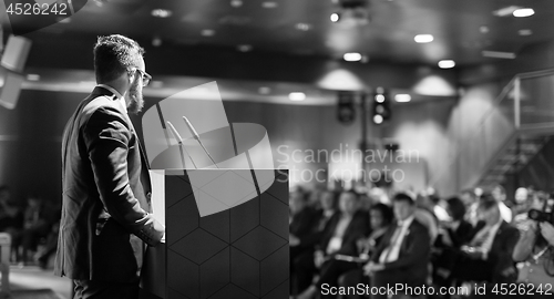 Image of Public speaker giving talk at business event.