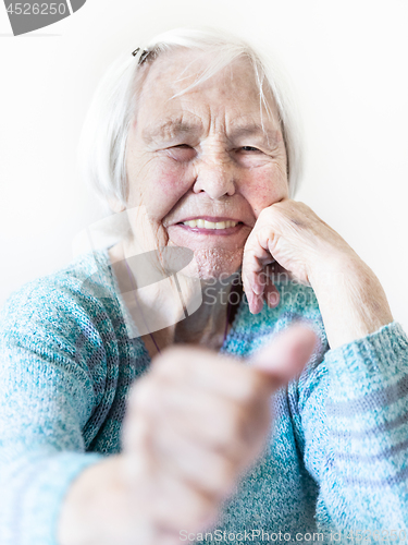 Image of Happy 96 years old elderly woman giving a thumb up and looking at camera.