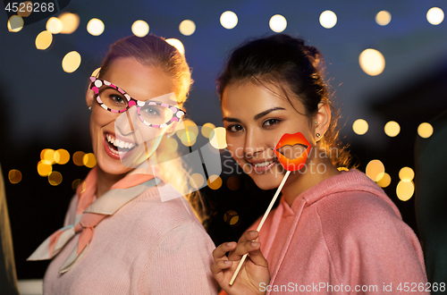 Image of happy women with party props at night