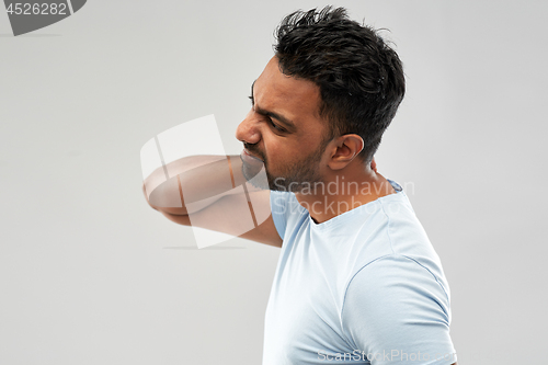 Image of unhealthy indian man suffering from neck pain