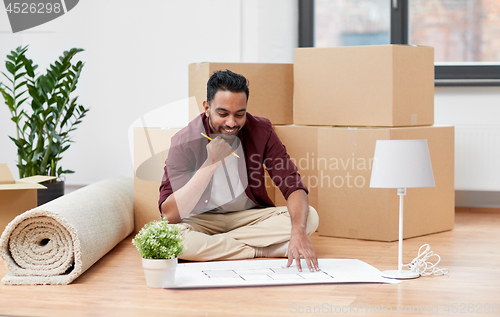 Image of man with boxes and blueprint moving to new home