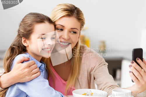 Image of family taking selfie by smartphone at breakfast