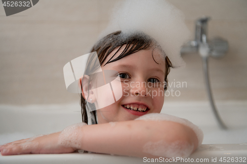 Image of little girl in bath playing with foam