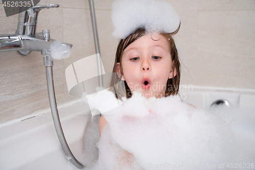 Image of little girl in bath playing with foam