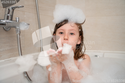 Image of little girl in bath playing with foam