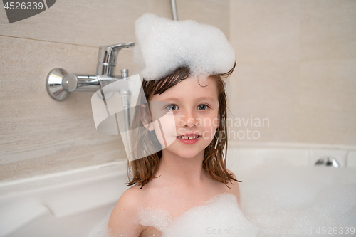 Image of little girl in bath playing with foam