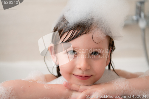 Image of little girl in bath playing with foam