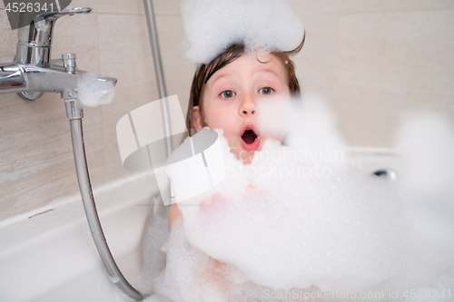 Image of little girl in bath playing with foam